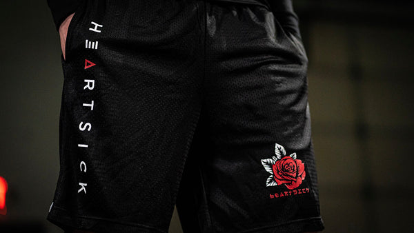 HEARTSICK ‘THE SNAKE AND THE ROSE’ mesh hockey shorts in black front view on model