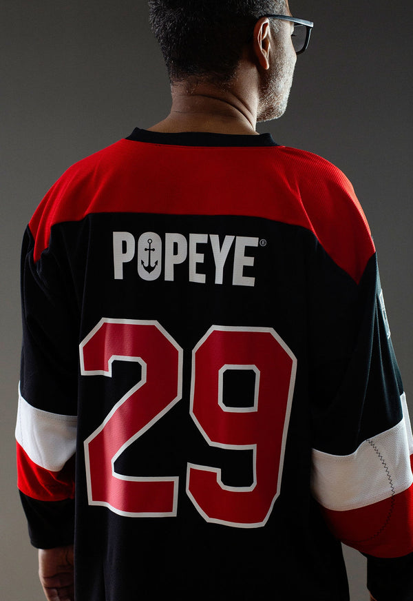 POPEYE 'STRONG TO THE FINISH' hockey jersey in black, red, and white back view on model