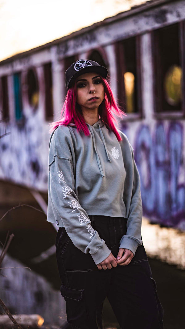 PUCK HCKY 'SHOOT PUCKS NOT PEOPLE - DRIPPY SCRIPT' women's cropped hockey hoodie in sage front view on model