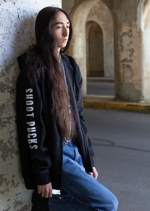 PUCK HCKY 'Shoot Pucks Not People - Television' full zip hockey hoodie in black side view on model