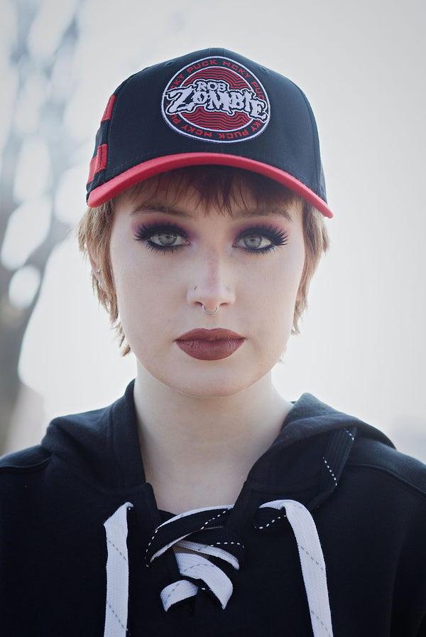 ROB ZOMBIE 'PUCK OF THE EARTH' stretch fit hockey cap in black with red brim and stripes front view on model