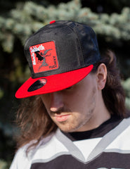 BLACK SABBATH ‘IRON MAN’ snapback hockey cap in black camo with red brim front view on model