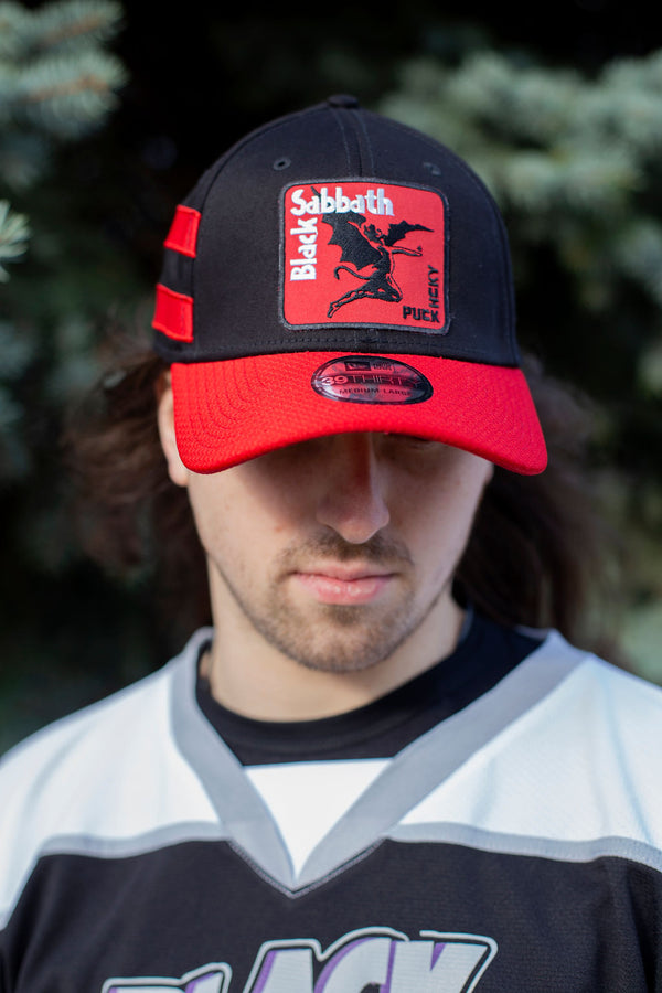 BLACK SABBATH ‘IRON MAN’ stretch fit hockey cap in black with red brim and stripes front view on model
