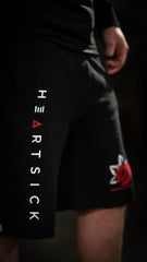 HEARTSICK ‘THE SNAKE AND THE ROSE’ fleece hockey shorts in black front view on model