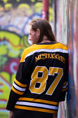MESHUGGAH 'KNÖVELMETAL' hockey jersey in black, gold, and white back view on model