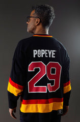 POPEYE 'STRONG TO THE FINISH' deluxe hockey jersey in black, red, and gold back view on model