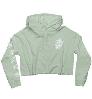 PUCK HCKY 'SHOOT PUCKS NOT PEOPLE - DRIPPY SCRIPT' women's cropped hockey hoodie in sage front view