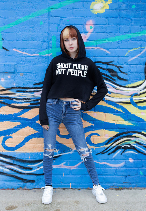 PUCK HCKY 'SHOOT PUCKS NOT PEOPLE - STACKED' women's pullover crop hockey hoodie in black on model